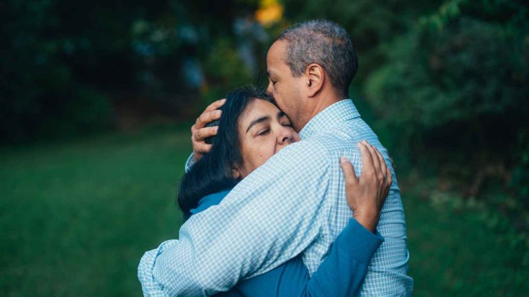A middle aged couple hug to celebrate his recovery on this National Cancer Survivor's Day