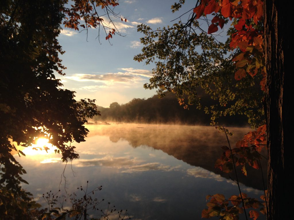 A beautiful river with trees at the edge at sunrise where you can pray a morning prayer for spiritual strength.