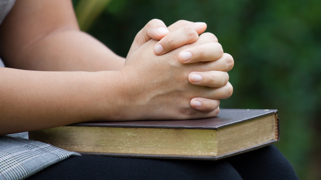 Royalty-free stock photo: A woman meditates over Bible verses.