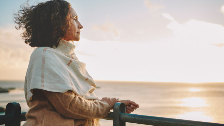Royalty-Free Stock Photo: Woman looking out at the sunset while truth-seeking.