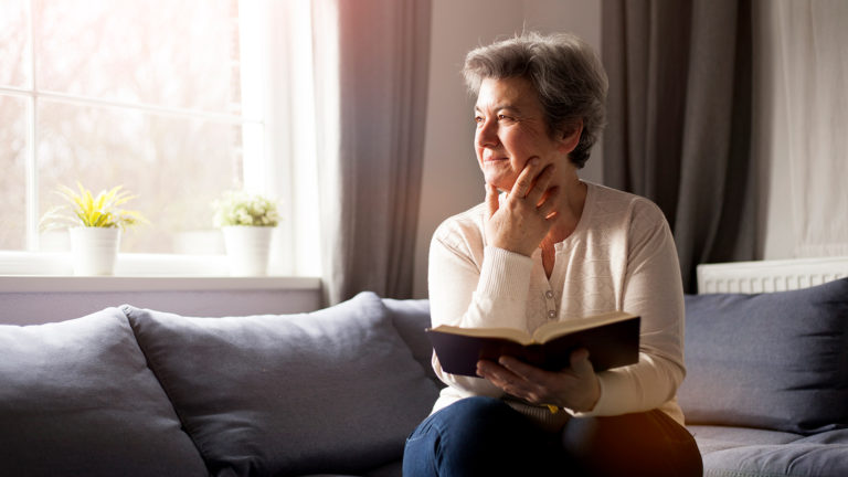 Royalty-Free Stock Photo: Senior woman reading the Bible to increase emotional stability.