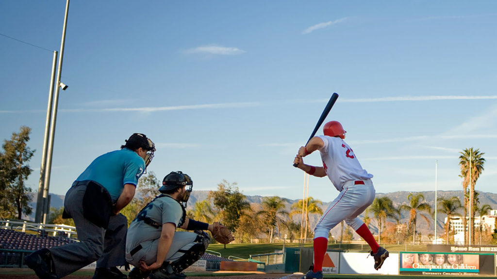 An umpire, catch and batter play baseball under a clear sky remembering that belief, like baseball, means taking action.