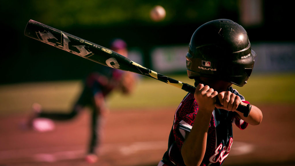 A young Little League baseball player awaits a pitch, wondering about some of life's biggest questions.