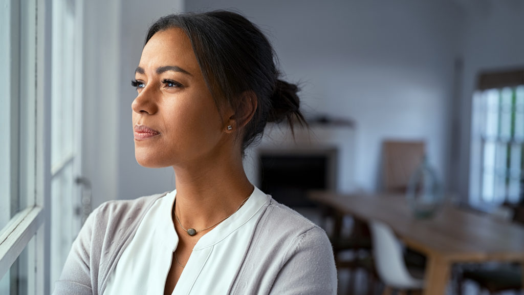 Royalty-free stock photo: A woman experiencing doubt gazes out a window