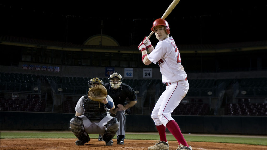 A baseball batter stands at home plate in front of the catcher and umpire ready for the pitch much like we're ready for spiritual growth.