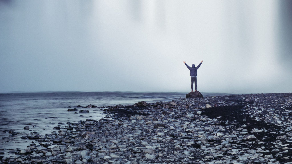 I man stands facing a roaring waterfall thankful that he told God "I want to see again."