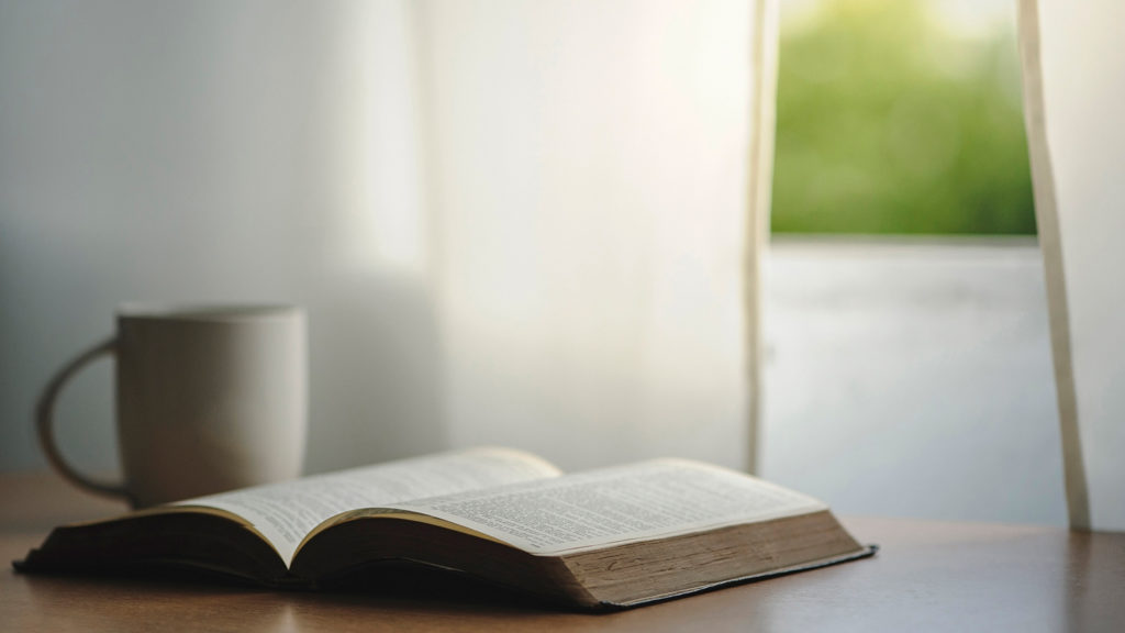 Royalty-Free Stock Photo: Bible placed next to a cup of coffee for early morning prayers.