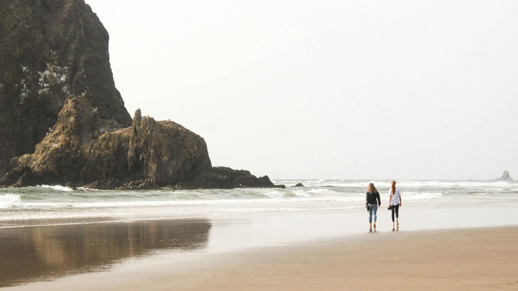 Two friends walk on a beach valuing that they feel listened to.